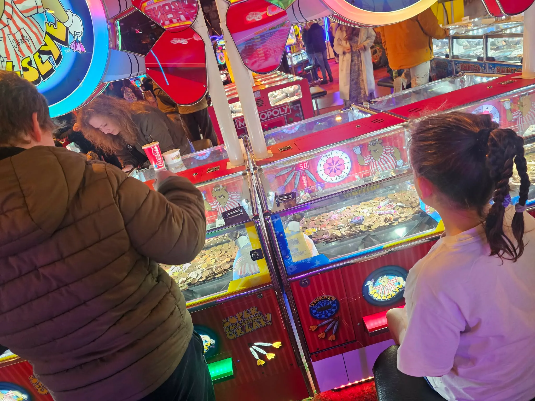 Children at a Blackpool seafront arcade, coins ready at the 2p machines