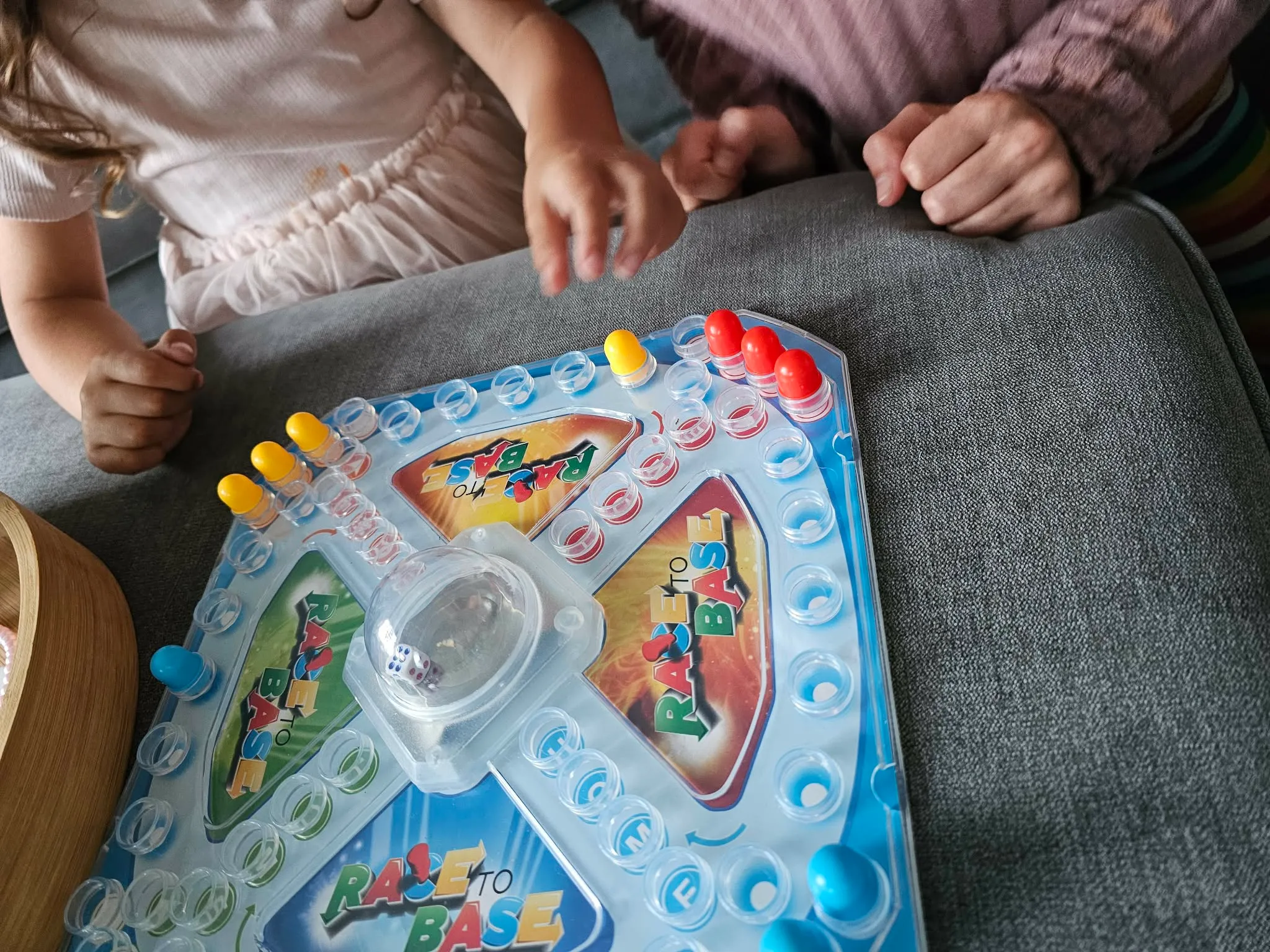 Two children and Jade mid-game around a board game on the sofa