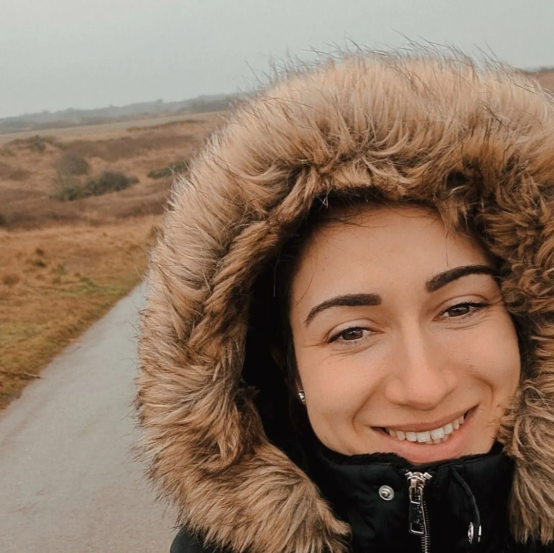 Jade, of Care by Jade, smiling on a coastal walk